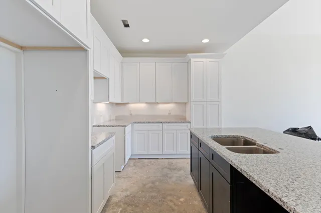 a kitchen with granite countertop white cabinets and white appliances