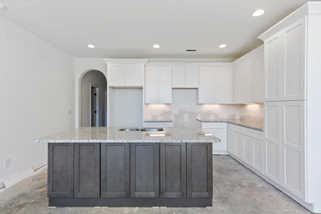 a kitchen with kitchen island granite countertop a sink stainless steel appliances and cabinets