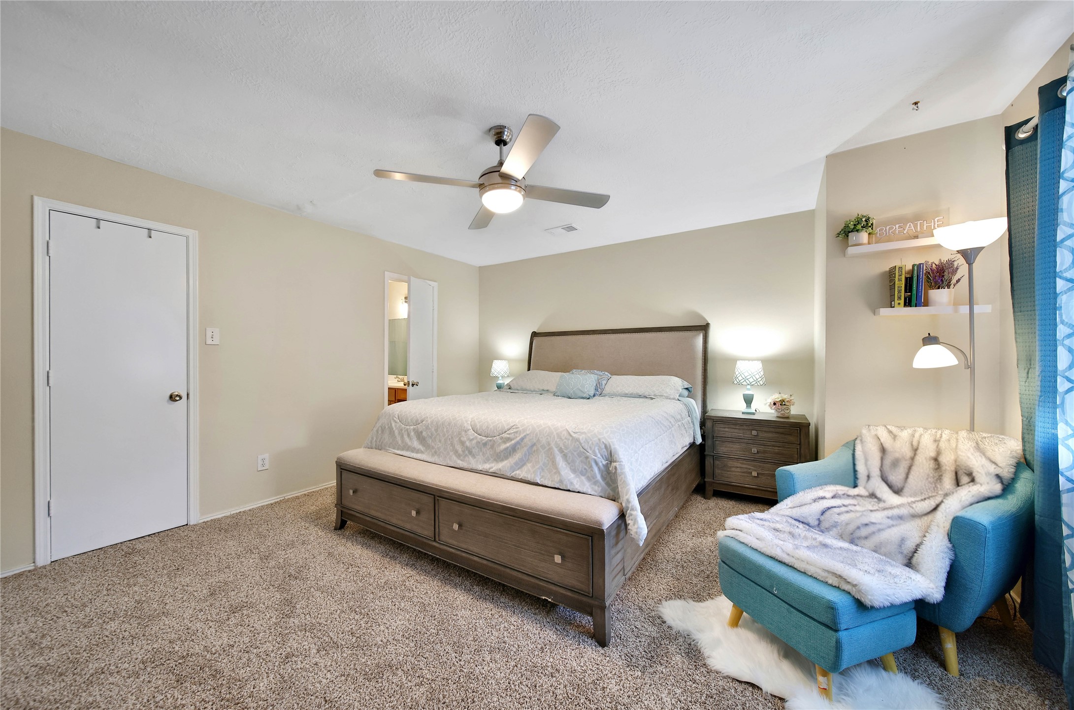17323 Lobo Trail Houston, TX 77084 - Photo 12 of 21 a spacious bedroom with a bed a couch and a chandelier