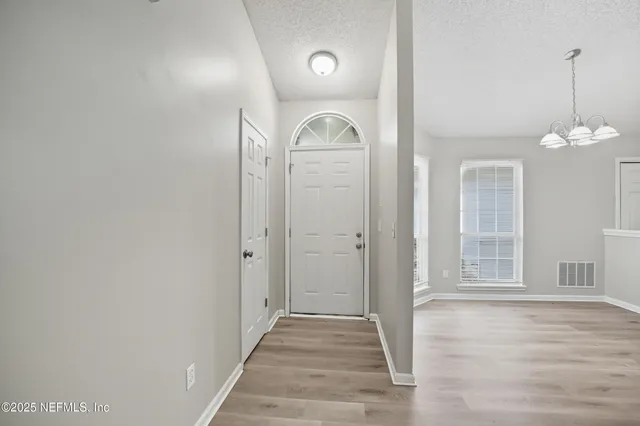 a view of a hallway with wooden floor and mirror