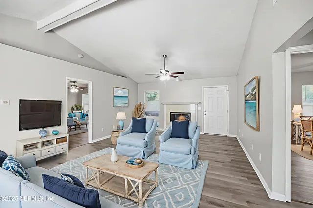a living room with furniture a flat screen tv and a fireplace