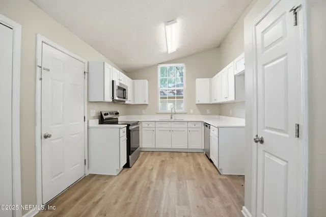 a kitchen with a refrigerator stove top oven and sink
