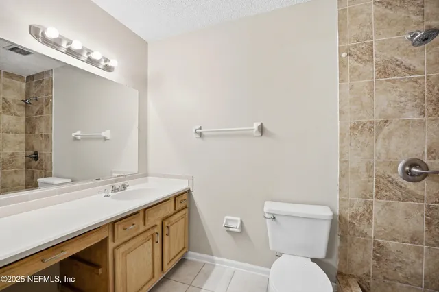 a bathroom with a sink a toilet a mirror and shower