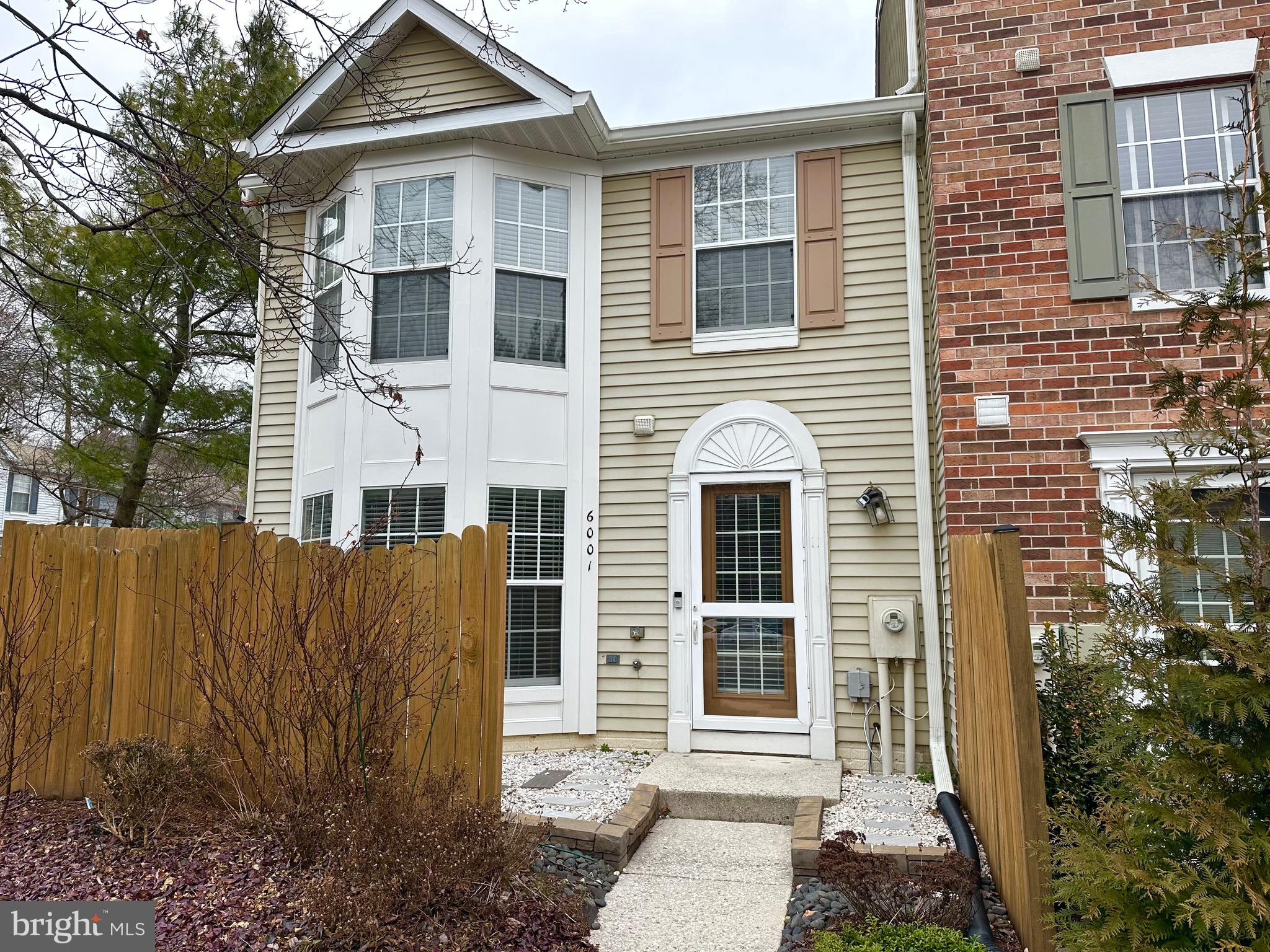 a view of a white house with large windows and plants