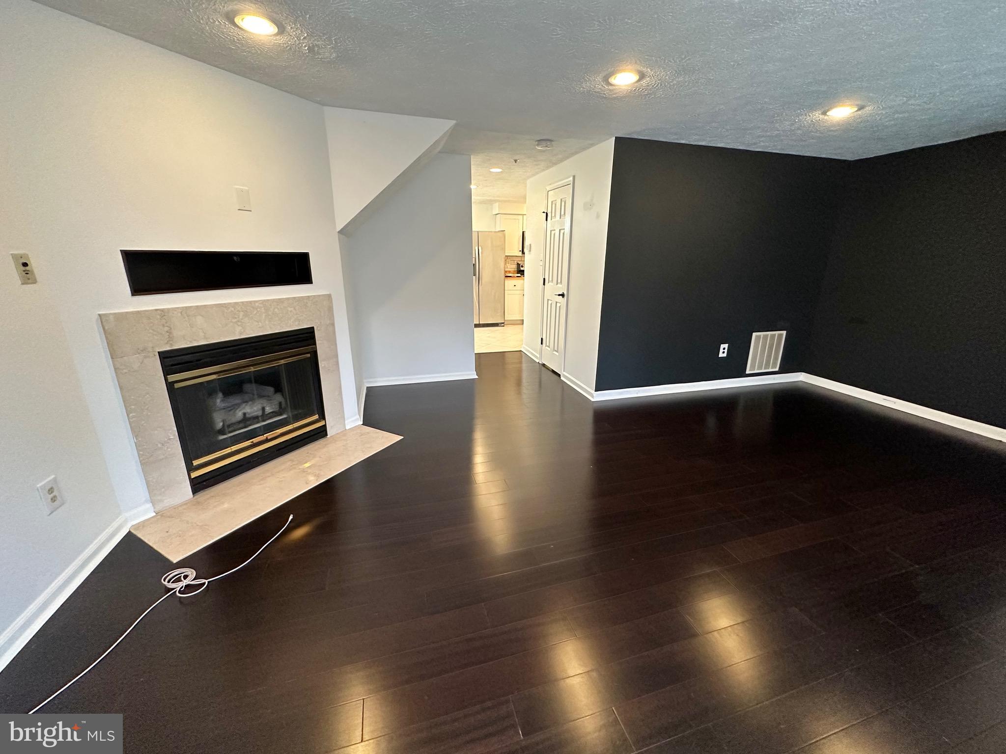 6001 Cloudy April Way Columbia, MD 21044 - Photo 3 of 12 a view of an empty room with wooden floor and a fireplace