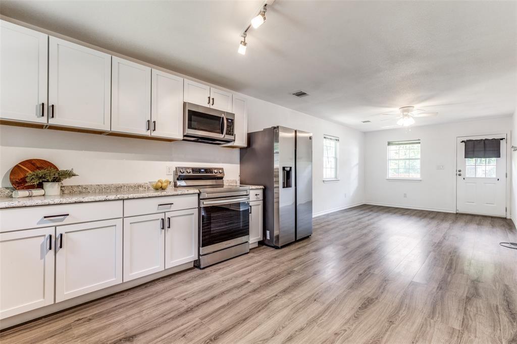 7659 Double Bridge Road Mabank, TX 75156 - Photo 6 of 22 Kitchen featuring appliances with stainless steel finishes, light wood-type flooring, a ceiling fan, white cabinetry, and rail lighting