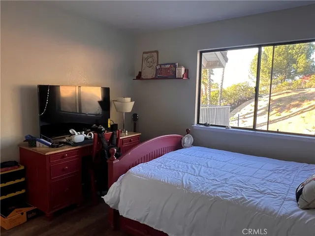 a bedroom with a bed and a flat screen tv