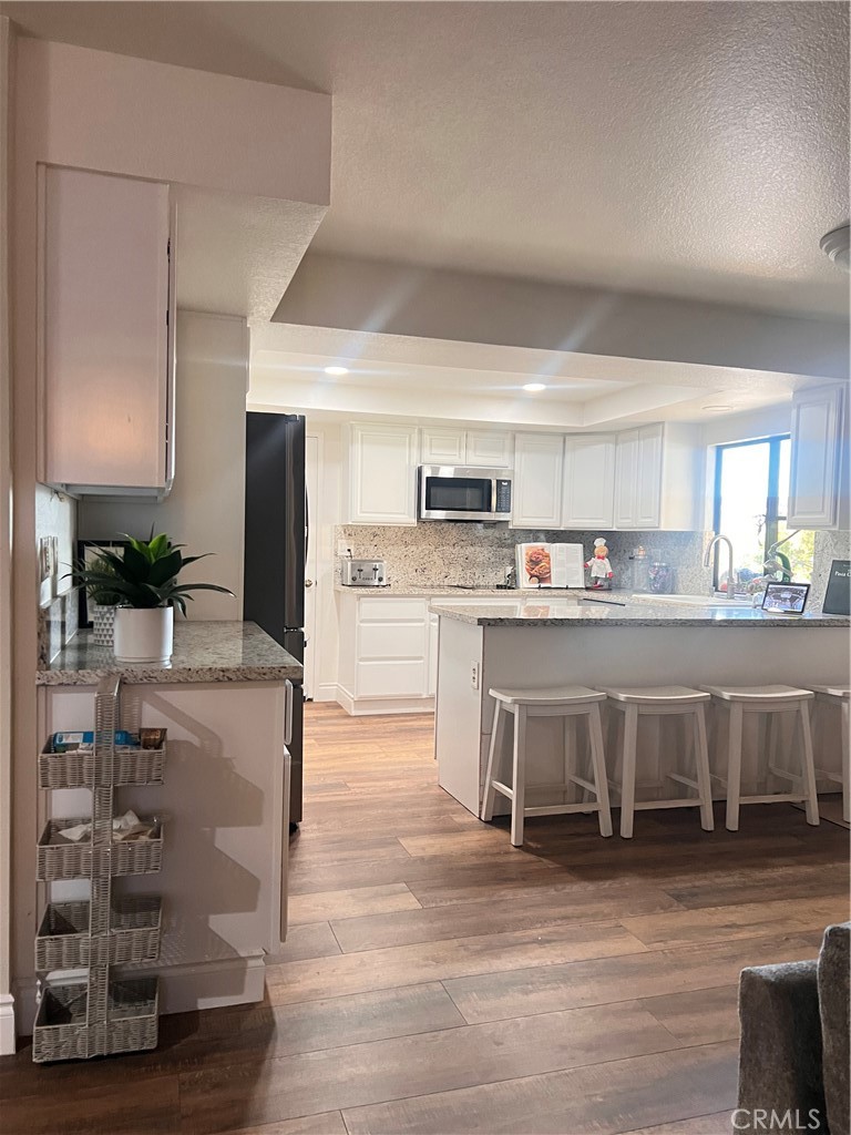 7158 Golden Vale Drive Riverside, CA 92506 - Photo 34 of 36 a large kitchen with stainless steel appliances granite countertop a table chairs sink and cabinets