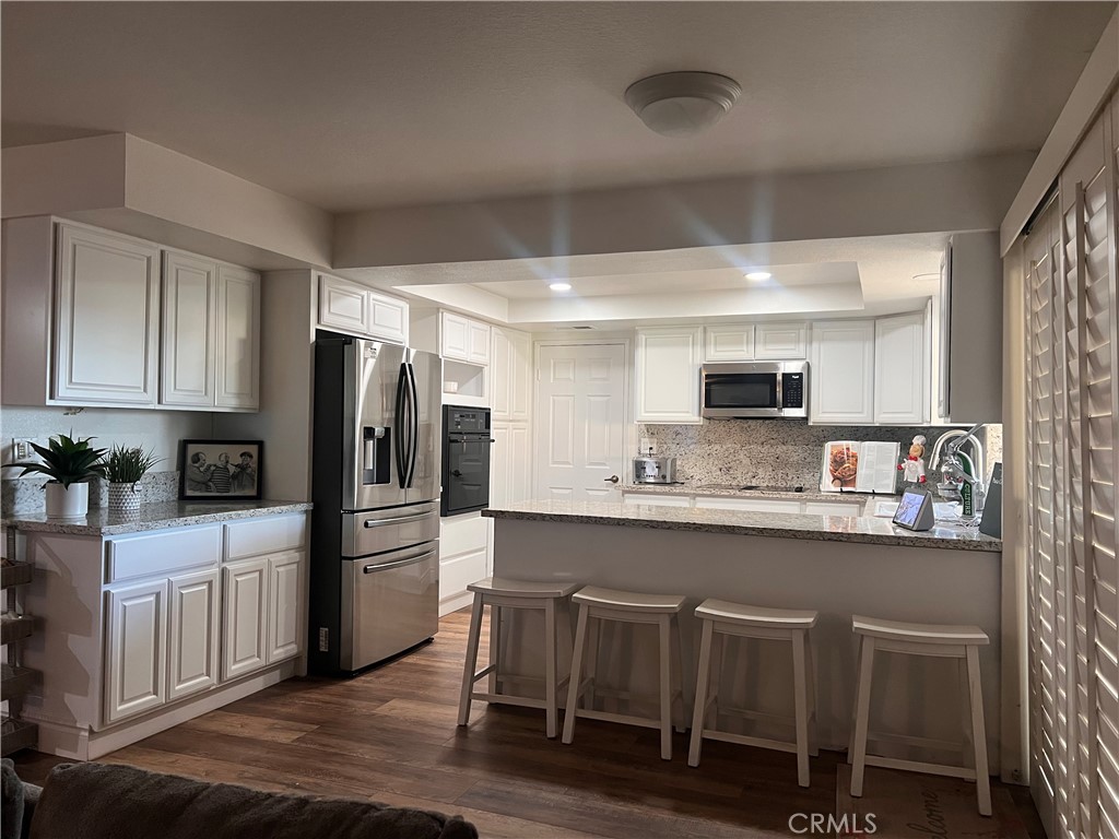 7158 Golden Vale Drive Riverside, CA 92506 - Photo 35 of 36 a kitchen with stainless steel appliances a microwave a sink and cabinets