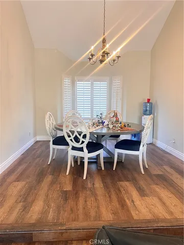 a dining room with furniture a chandelier and wooden floor