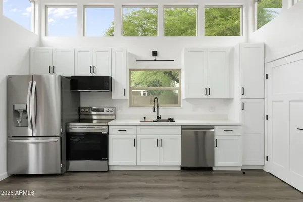 a kitchen with stainless steel appliances a stove a sink and a refrigerator