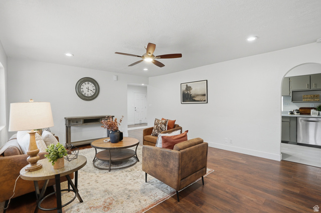 6889 South Village Road Salt Lake City, UT 84121 - Photo 8 of 44 Spacious living area featuring wood-finish flooring, a ceiling fan, recessed lighting, kitchen entrance.