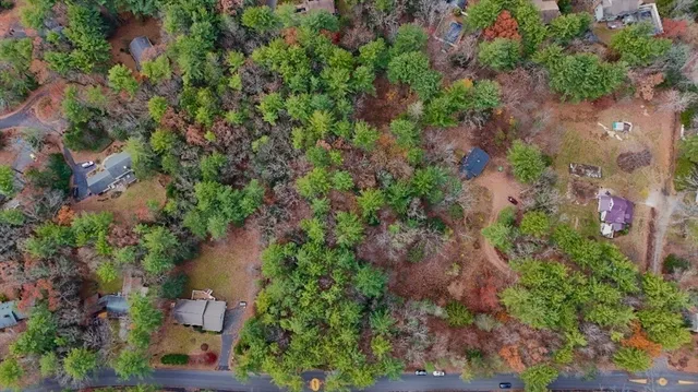 an aerial view of residential house with outdoor space and trees all around