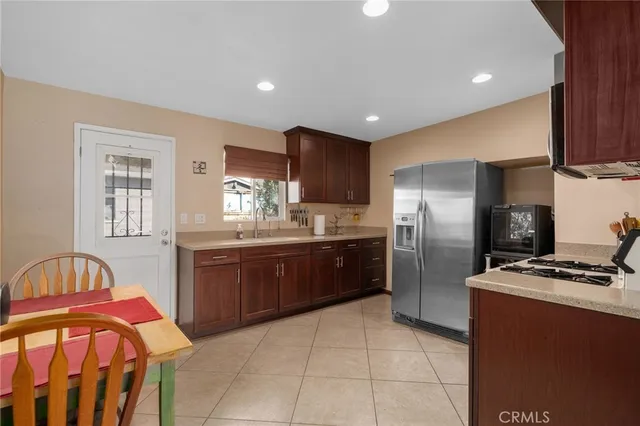 a kitchen with stainless steel appliances granite countertop a refrigerator a stove a sink and dishwasher