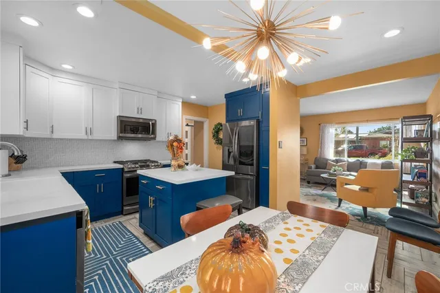 a large kitchen with kitchen island granite countertop a sink stainless steel appliances and white cabinets