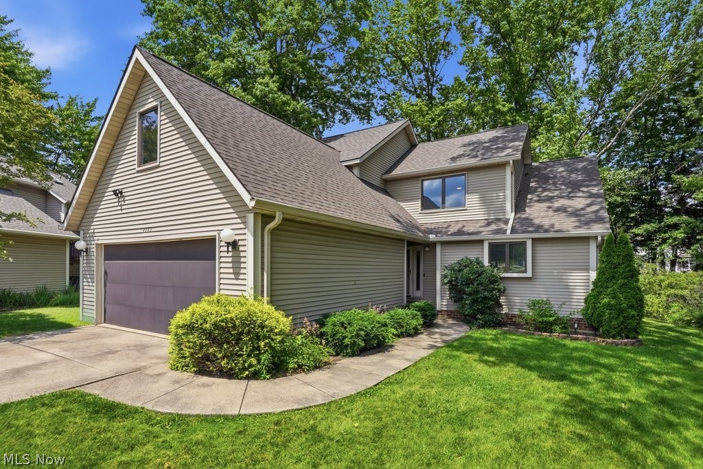 2323 Call Road Stow, OH 44224 - Photo 1 of 42 Contemporary home featuring multi-pane windows, a dark shingled roof, light-toned siding, an attached garage with a dark door, and a concrete driveway