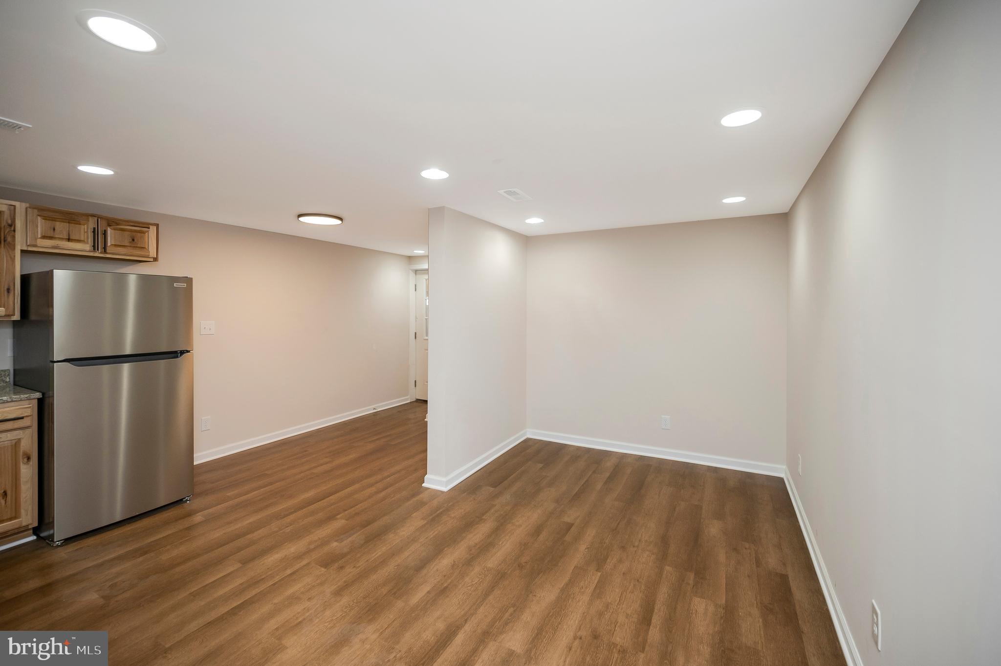 5200 Hams Ford Road Woodford, VA 22580 - Photo 34 of 51 a view of an empty room with wooden floor and a refrigerator
