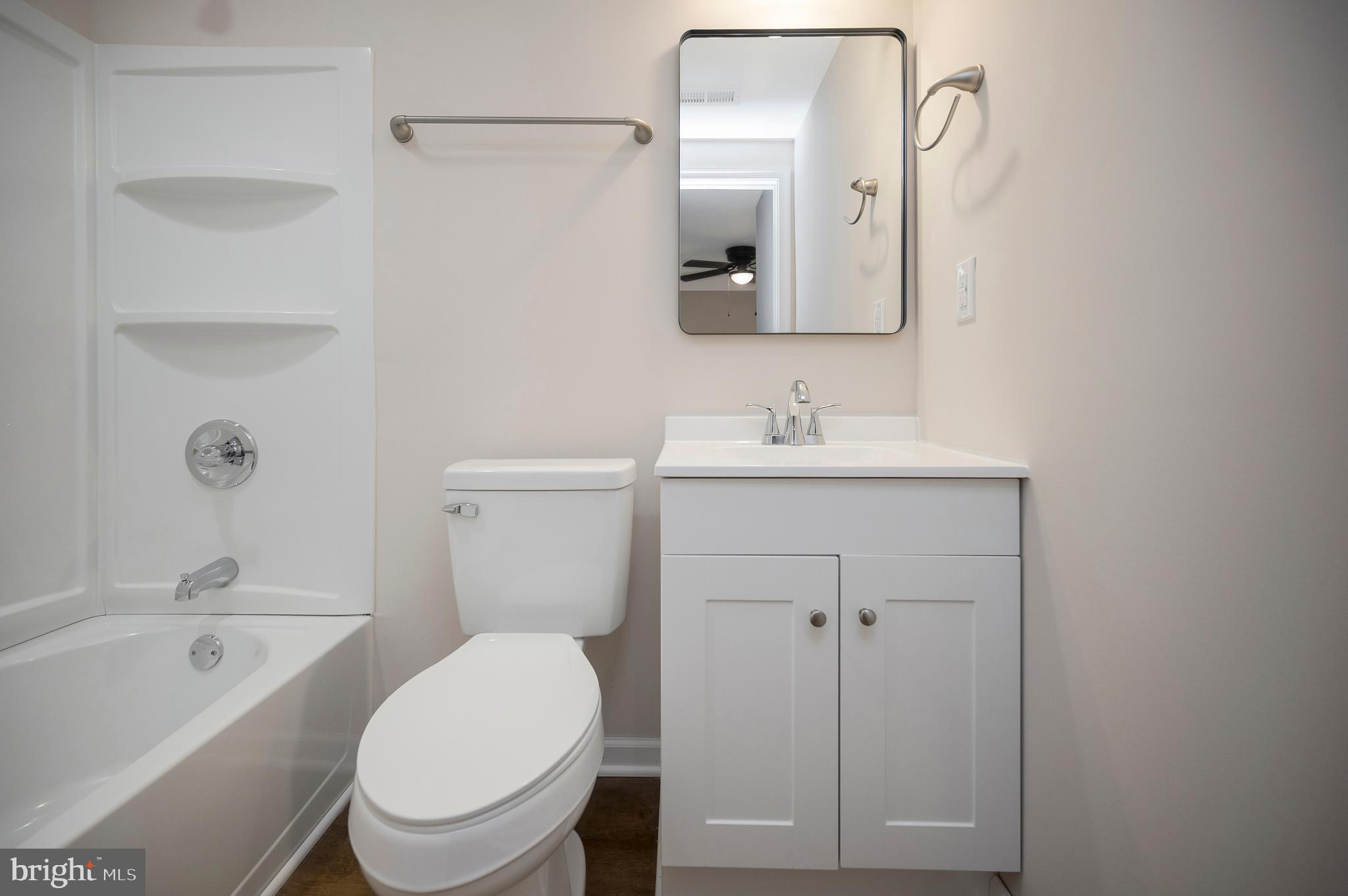 5200 Hams Ford Road Woodford, VA 22580 - Photo 39 of 51 a bathroom with a toilet a sink a mirror a bathtub and vanity