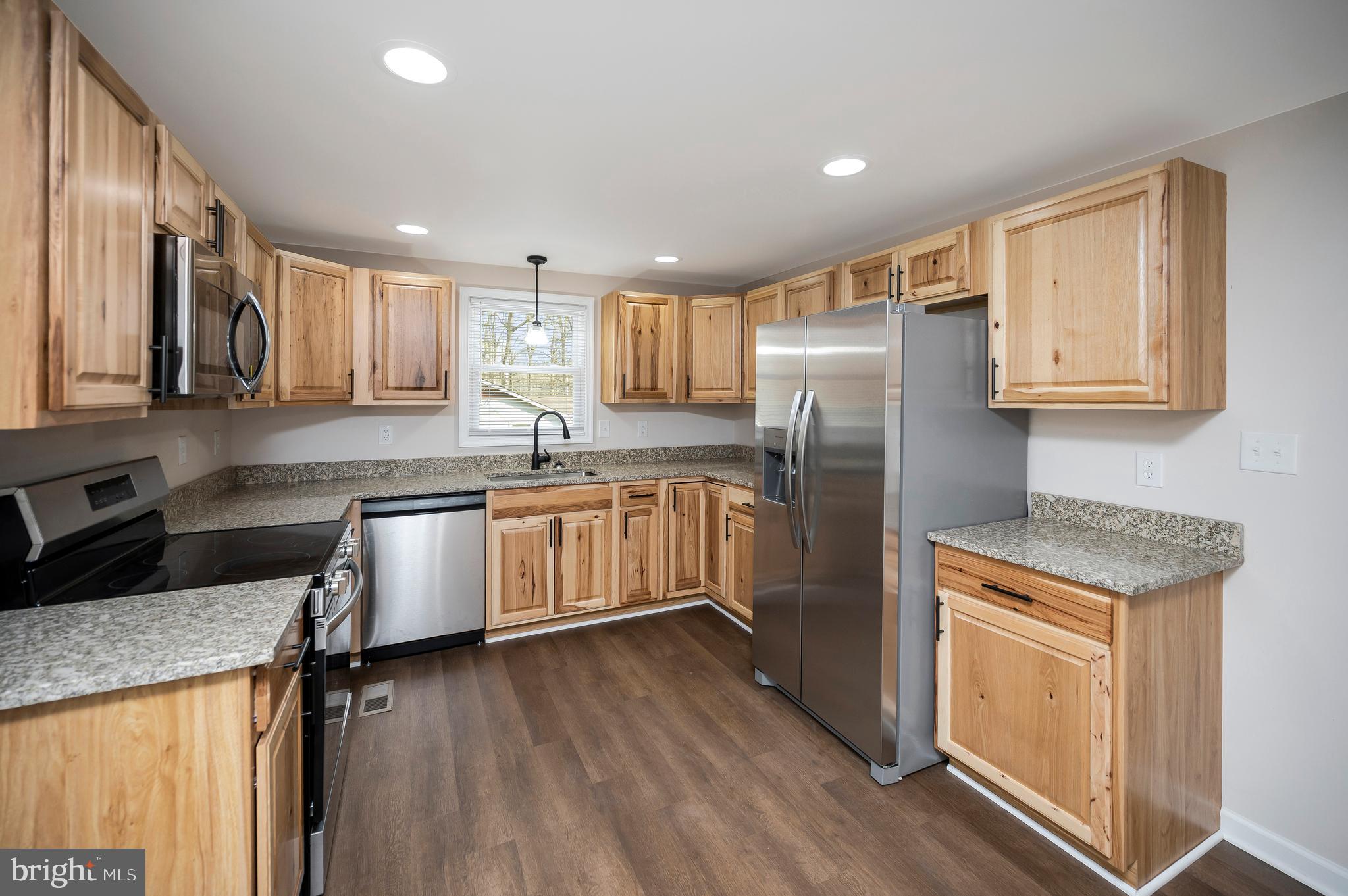 5200 Hams Ford Road Woodford, VA 22580 - Photo 6 of 51 a kitchen with granite countertop stainless steel appliances a refrigerator cabinets and wooden floor