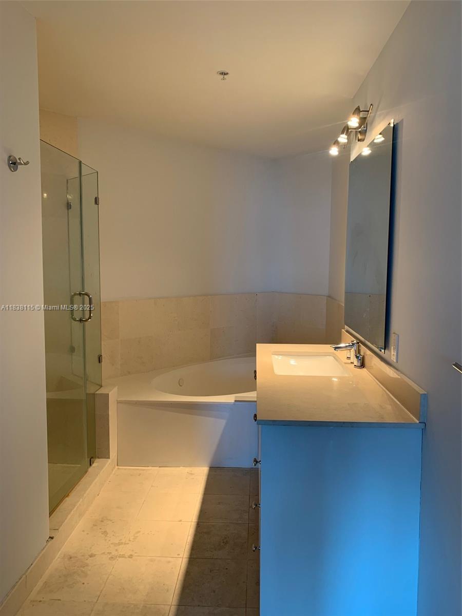 60 Southwest 13th Street, Unit 3826 Miami, FL 33130 - Photo 25 of 29 a bathroom with a tub and a shower