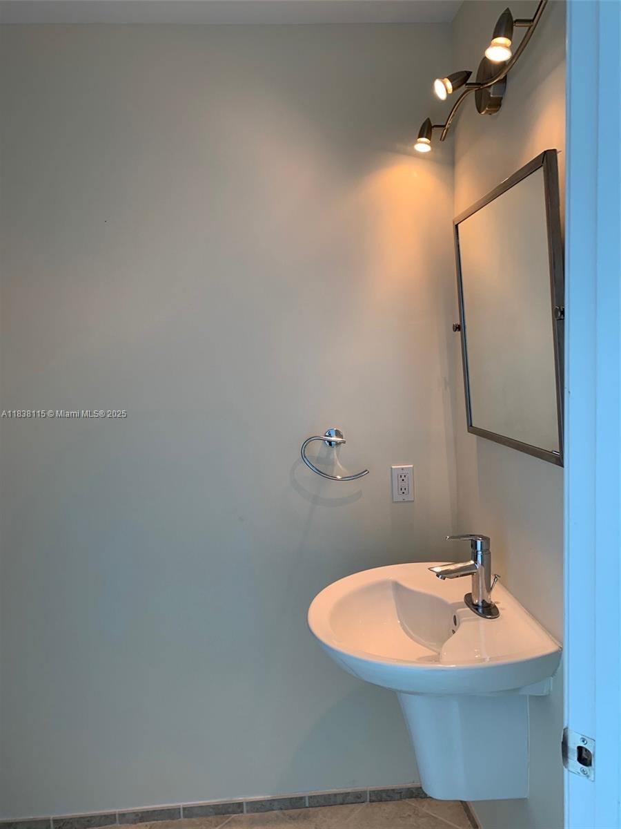 60 Southwest 13th Street, Unit 3826 Miami, FL 33130 - Photo 29 of 29 a bathroom with a sink and mirror