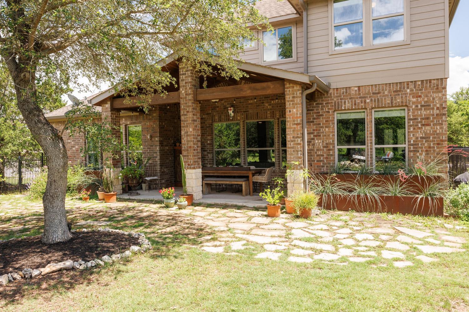 1135 Blue Ridge Drive Dripping Springs, TX 78620 - Photo 29 of 36 Brick veneer and siding adorn this home's exterior, offering a covered patio for outdoor gatherings.