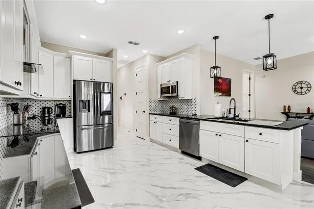 a kitchen with white cabinets and stainless steel appliances