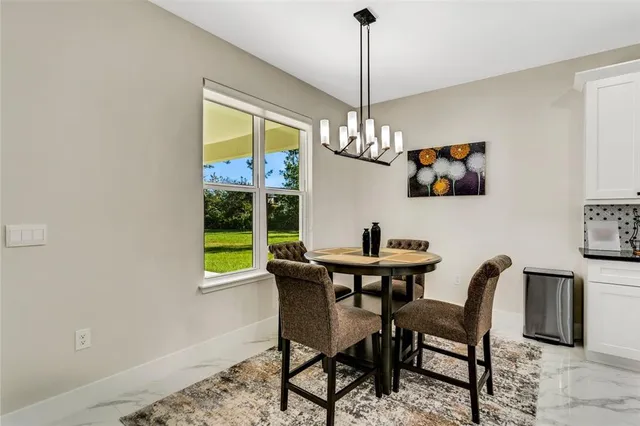 a view of a dining room with furniture a chandelier and wooden floor