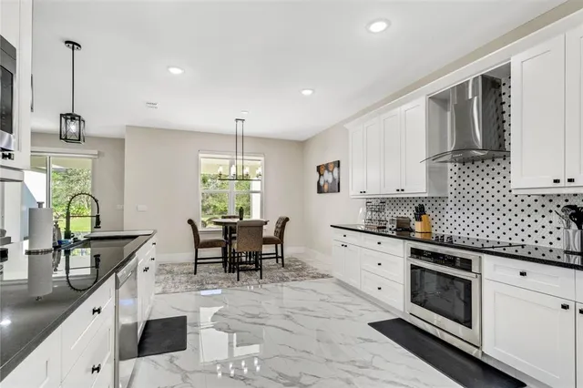 a kitchen with stainless steel appliances kitchen island granite countertop a stove a sink and a refrigerator
