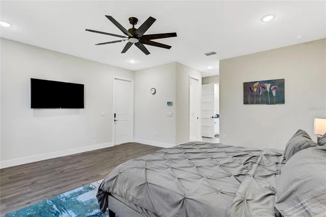 a bedroom with a large bed and a flat screen tv