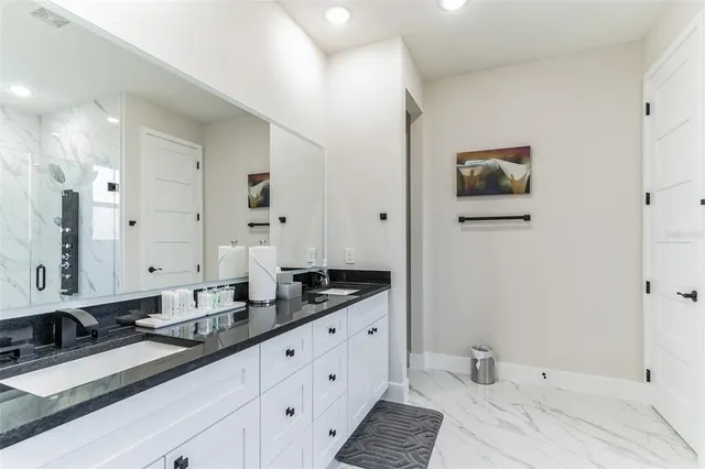 a spacious bathroom with a double vanity sink and mirror