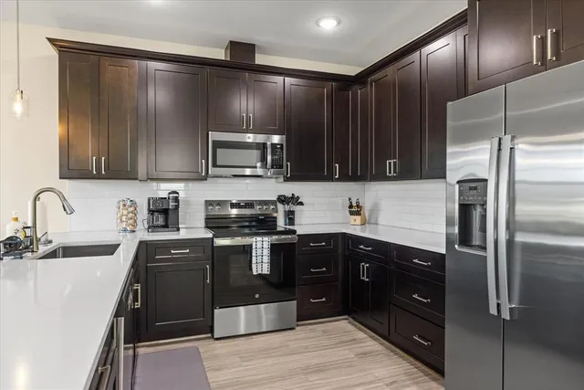 a kitchen with kitchen island granite countertop stainless steel appliances and sink