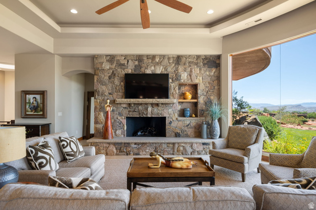 2331 West Entrada Trail, Unit 61 St. George, UT 84770 - Photo 19 of 69 Living area featuring a stone fireplace with hearth, built-in shelving, and a wood ceiling fan