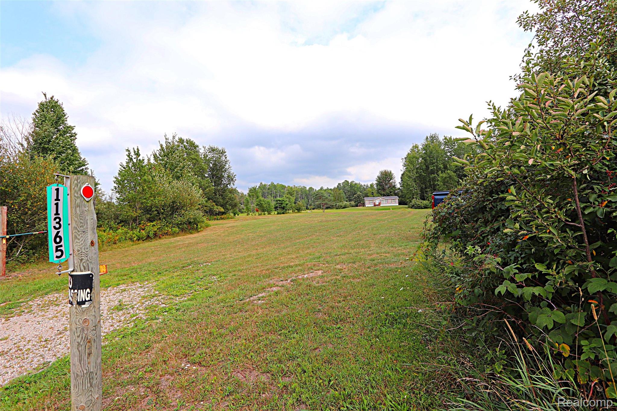 11365 Littlefield Road Blanchard, MI 49310 - Photo 31 of 68 Expansive cleared land featuring a wooded perimeter and distant outbuilding