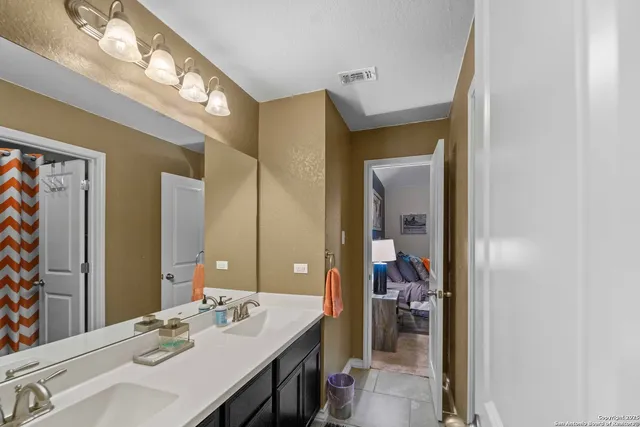 a bed sitting in a bedroom next to a window and a chair