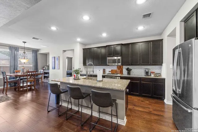 a kitchen with granite countertop a center island stainless steel appliances cabinets and a counter top space