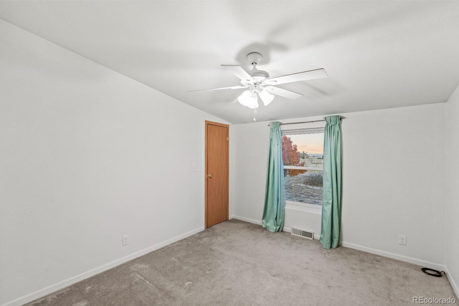 21105 McDaniels Road Calhan, CO 80808 - Photo 13 of 32 an empty room with fan and entrance