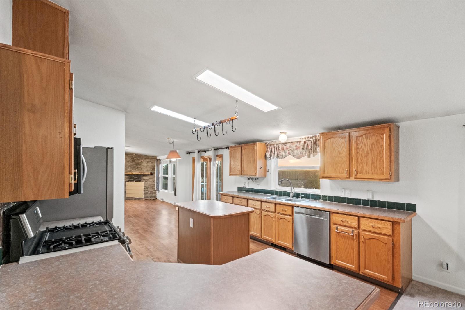 21105 McDaniels Road Calhan, CO 80808 - Photo 7 of 32 a kitchen with stainless steel appliances kitchen island granite countertop a stove a sink and a refrigerator
