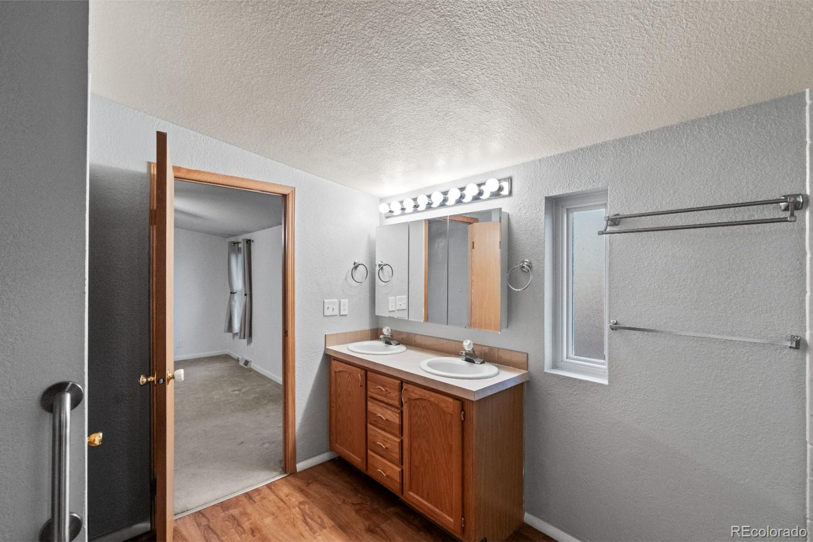 21105 McDaniels Road Calhan, CO 80808 - Photo 10 of 32 a bathroom with a double vanity sink and a mirror