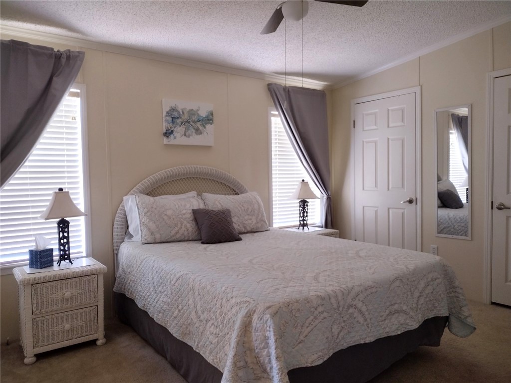 7490 133rd Place Sebastian, FL 32958 - Photo 10 of 25 a bedroom with a large bed and a chandelier