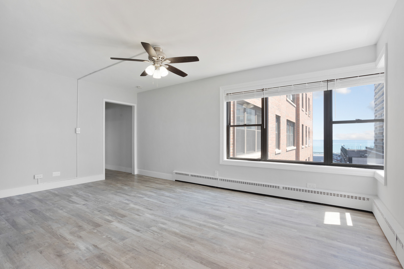 5858 North Sheridan Road, Unit 508 Chicago, IL 60660 - Photo 8 of 17 an empty room with wooden floor and windows