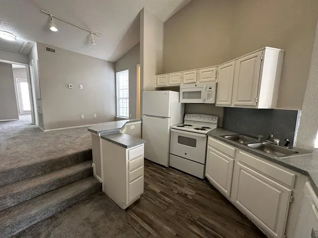 a kitchen with a stove and white cabinets