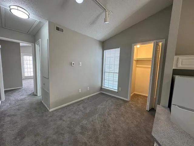 an empty room with windows and closet