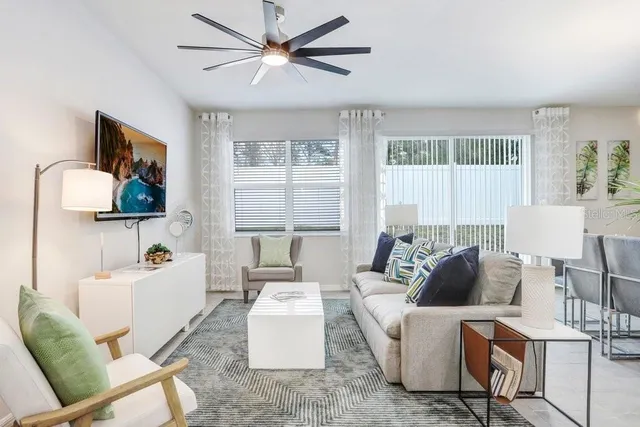 a living room with furniture kitchen view and a wooden floor