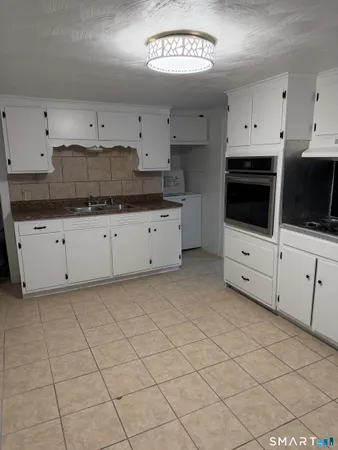 a kitchen with granite countertop white cabinets and stainless steel appliances