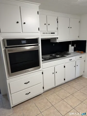 a kitchen with white cabinets appliances and a sink