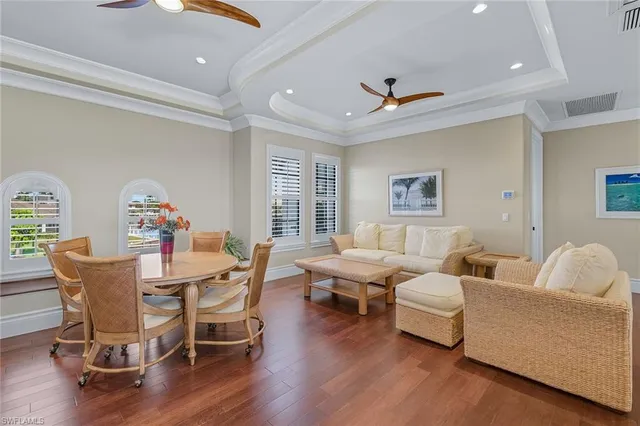 a dining room with furniture a chandelier and wooden floor