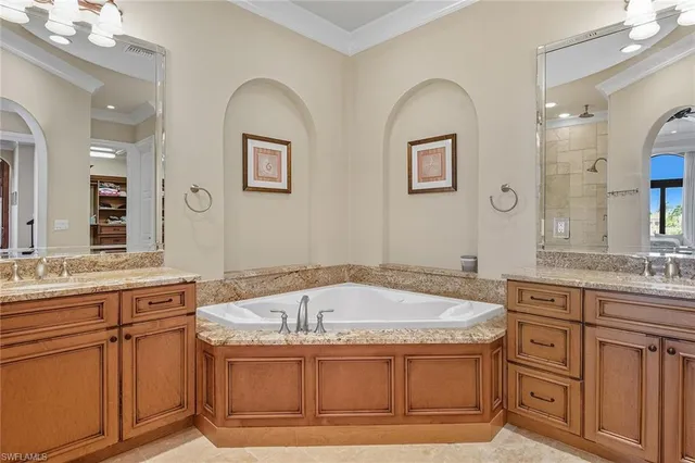 a spacious bathroom with a granite countertop sink a mirror a bathtub and shower