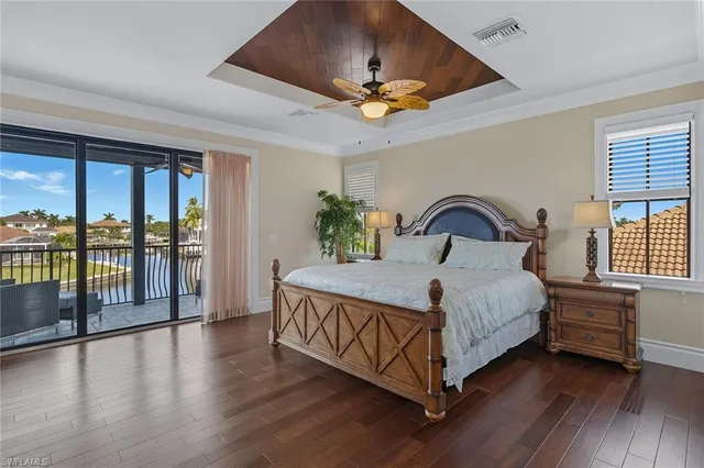 a bed sitting in a spacious bedroom next to a large window