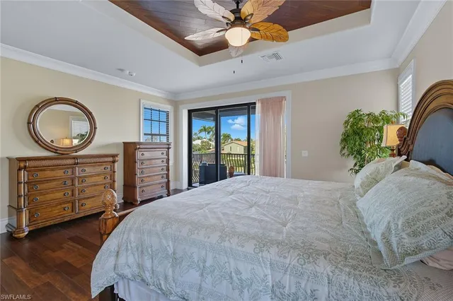 a bedroom with a bed a dresser and a chandelier